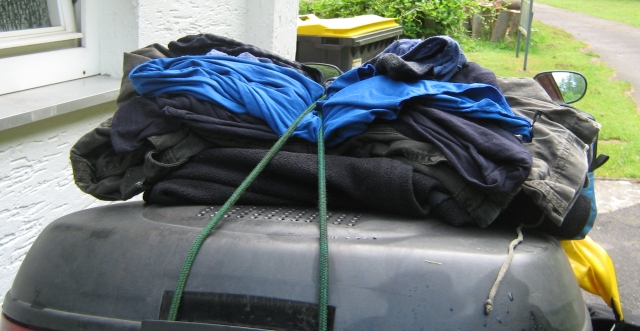 a few slothes trapped beneath bungee cords on the top box of the motorcycle to dry them as I ride